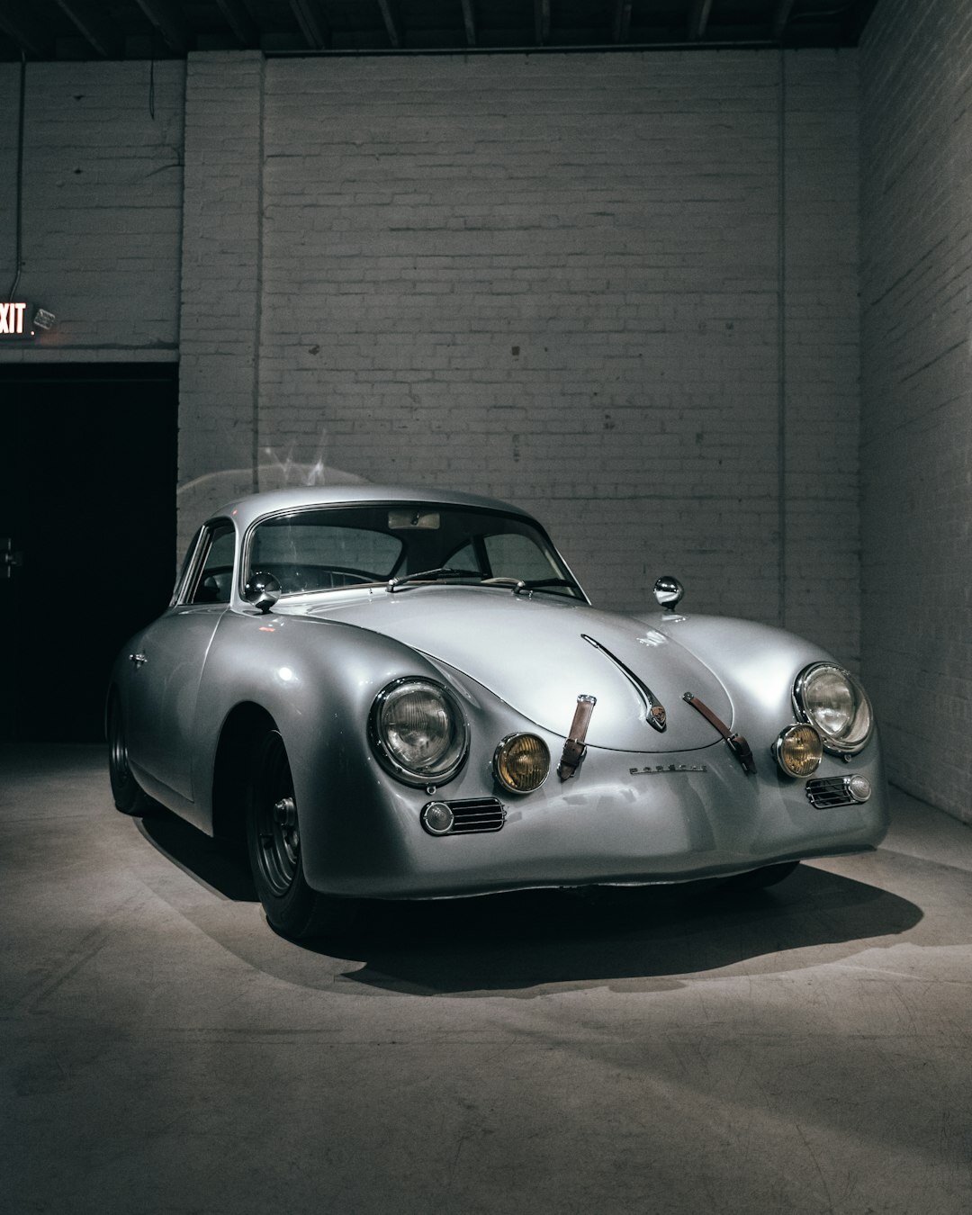 Private warehouse collection with rare classic cars under dramatic lighting